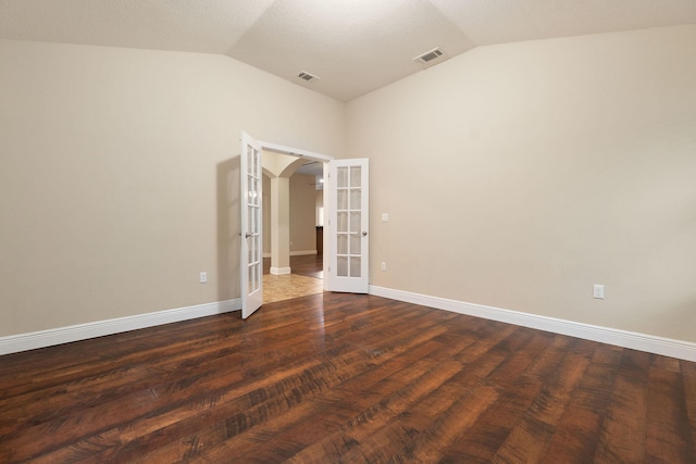 empty room with french doors, dark hardwood / wood-style flooring, and lofted ceiling