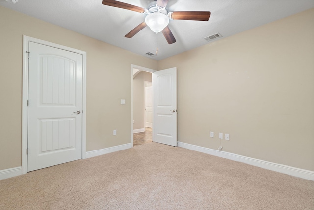 unfurnished bedroom with ceiling fan and light colored carpet