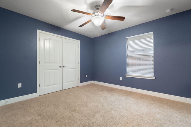 unfurnished bedroom with carpet flooring, ceiling fan, and a closet