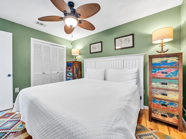 bedroom with ceiling fan, a closet, and light hardwood / wood-style flooring