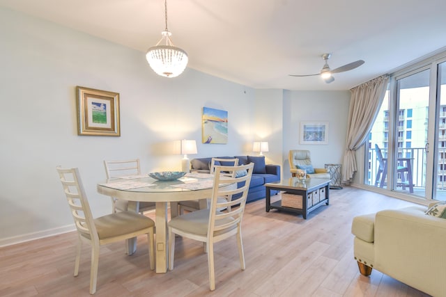 dining space featuring a ceiling fan, floor to ceiling windows, light wood-style flooring, and baseboards