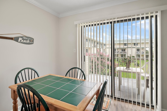 dining area featuring hardwood / wood-style floors and crown molding