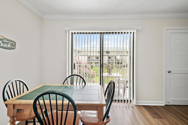 dining space featuring wood-type flooring and ornamental molding