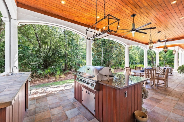 view of patio / terrace featuring an outdoor kitchen, area for grilling, ceiling fan, a sink, and outdoor dining space