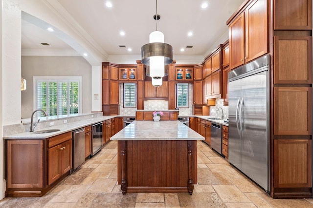 kitchen featuring stainless steel appliances, a sink, a center island, and stone tile floors