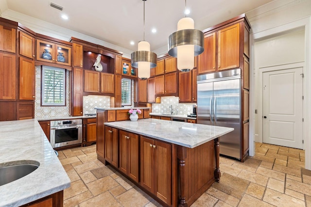 kitchen with stainless steel appliances, a center island, visible vents, and stone tile floors