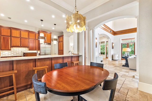 dining area with arched walkways, ornamental molding, visible vents, and stone tile floors