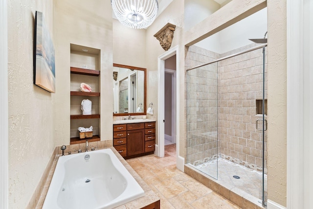 bathroom with a stall shower, a textured wall, a garden tub, vanity, and built in shelves