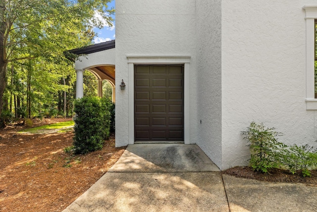 doorway to property featuring stucco siding