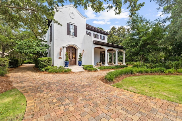 mediterranean / spanish-style home with a front yard and stucco siding