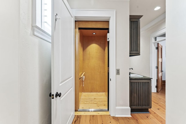 hallway featuring a sink and wood finished floors