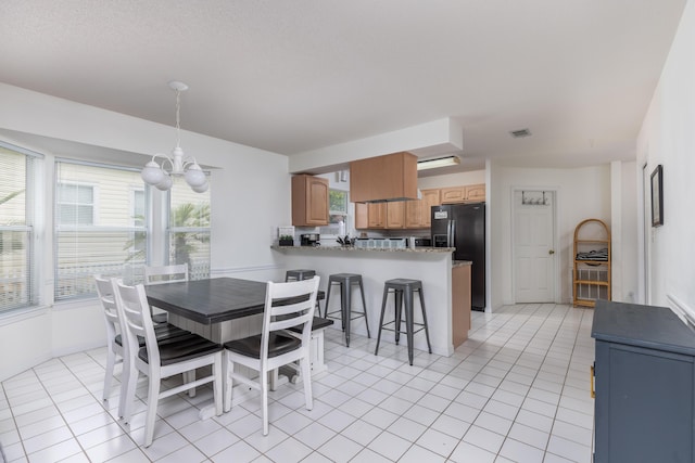 dining area featuring a notable chandelier, plenty of natural light, and light tile patterned floors