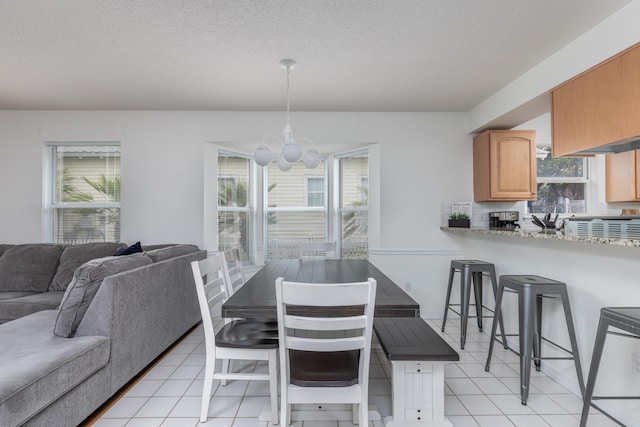 dining area featuring plenty of natural light, a textured ceiling, and light tile patterned flooring