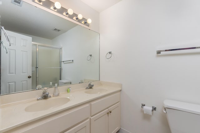 bathroom featuring vanity, toilet, and an enclosed shower