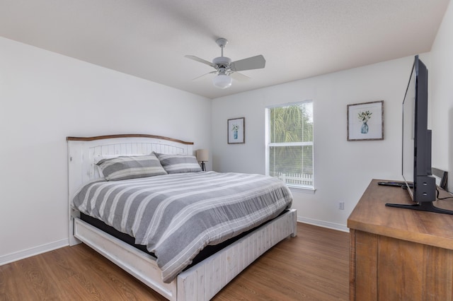 bedroom featuring hardwood / wood-style flooring, ceiling fan, and a textured ceiling