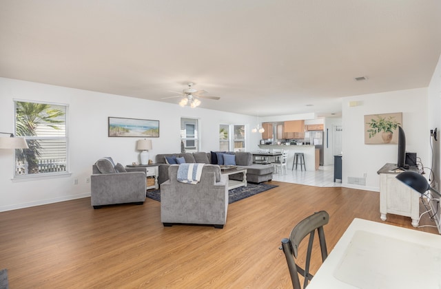 living room featuring ceiling fan and light hardwood / wood-style floors