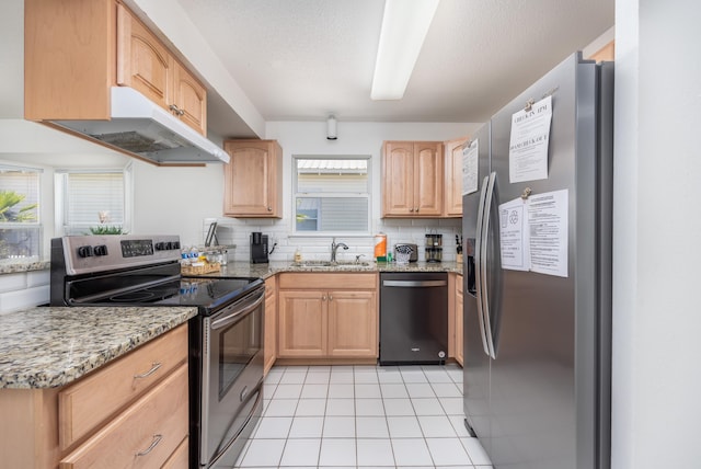 kitchen with tasteful backsplash, sink, stainless steel appliances, light stone countertops, and light brown cabinets