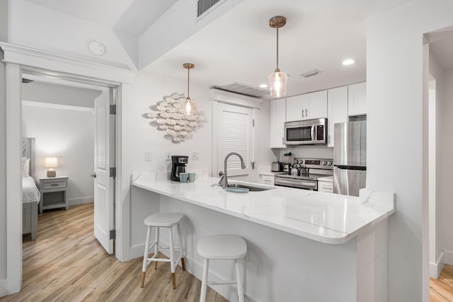 kitchen featuring pendant lighting, sink, kitchen peninsula, and stainless steel appliances