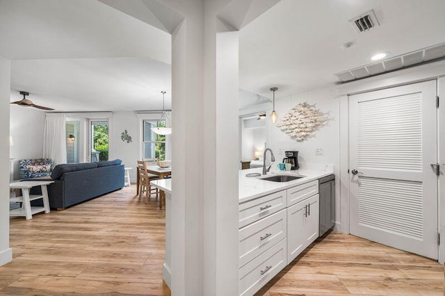 kitchen featuring ceiling fan, sink, decorative light fixtures, dishwasher, and white cabinetry