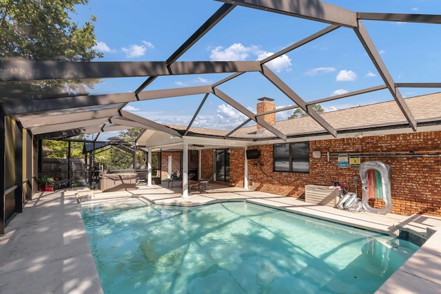 view of pool featuring a lanai, a patio, and a hot tub