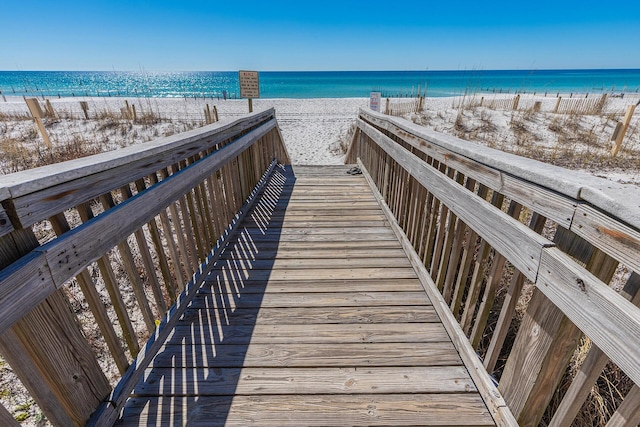 surrounding community featuring a water view and a beach view