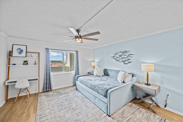 bedroom featuring crown molding, wood-type flooring, a textured ceiling, and ceiling fan