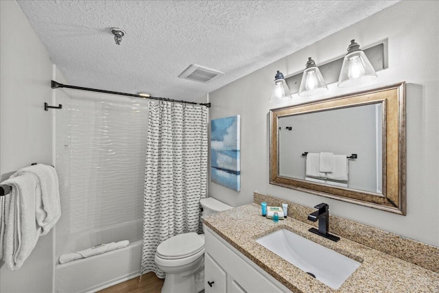 full bathroom with shower / tub combo with curtain, hardwood / wood-style floors, vanity, a textured ceiling, and toilet