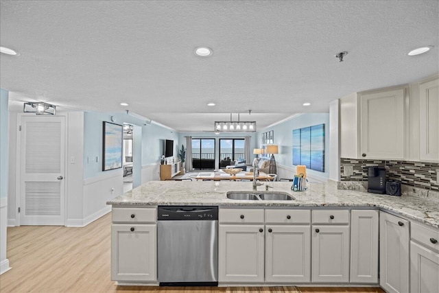 kitchen with white cabinetry, dishwasher, sink, kitchen peninsula, and light stone countertops