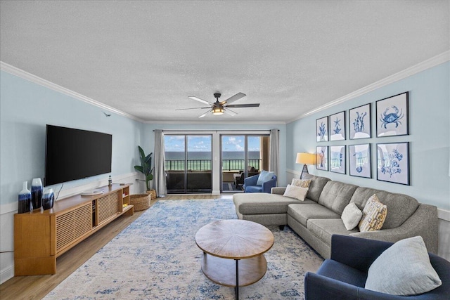 living room featuring ornamental molding, wood-type flooring, and a textured ceiling