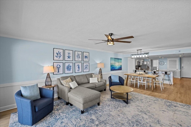 living room featuring ornamental molding, hardwood / wood-style floors, and a textured ceiling