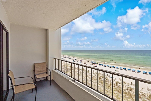 balcony featuring a beach view and a water view
