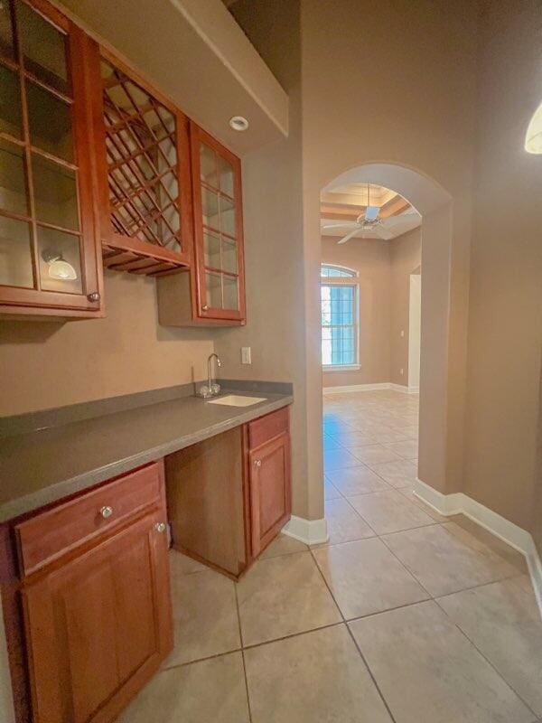 kitchen with light tile patterned floors, ceiling fan, and sink