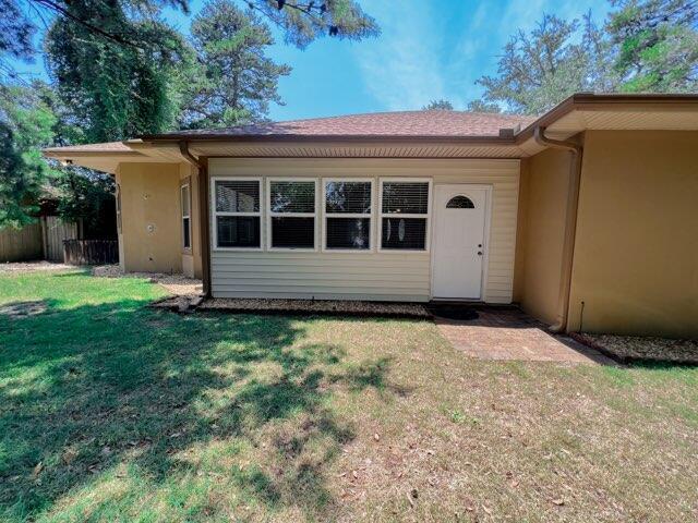 doorway to property with a lawn