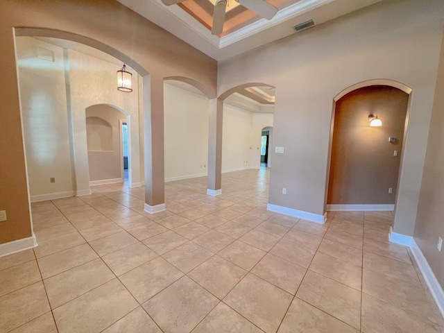 spare room featuring a raised ceiling, ceiling fan, and light tile patterned flooring