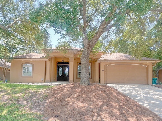 pueblo-style house featuring french doors and a garage