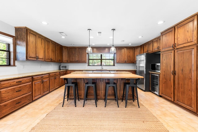 kitchen with a healthy amount of sunlight, a center island, and light tile floors