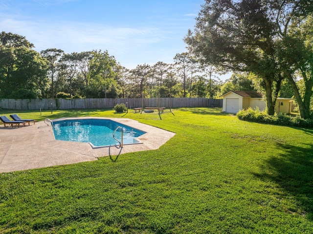 view of swimming pool with a garage, a patio area, a yard, and an outdoor structure