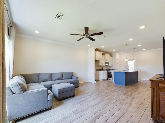 living room with sink, light hardwood / wood-style flooring, ornamental molding, and ceiling fan