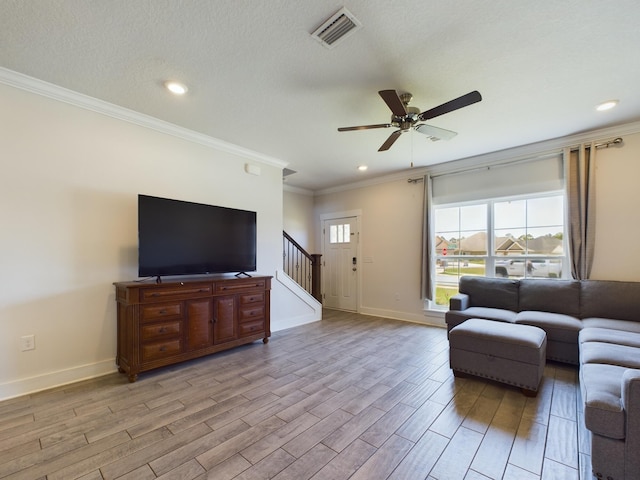 living room featuring crown molding, ceiling fan, and a textured ceiling