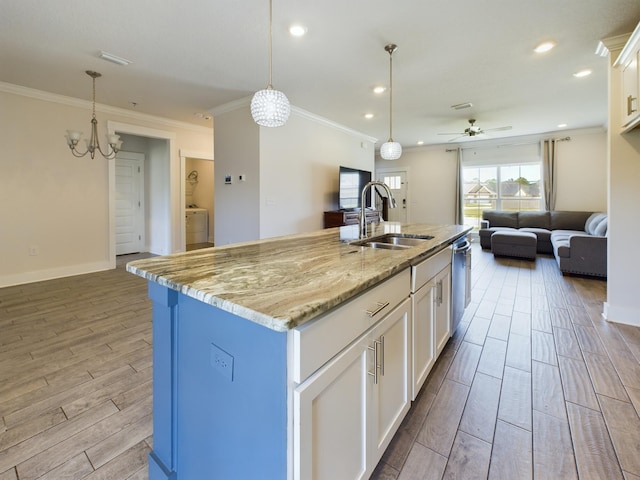 kitchen with white cabinetry, sink, a kitchen island with sink, and light stone countertops