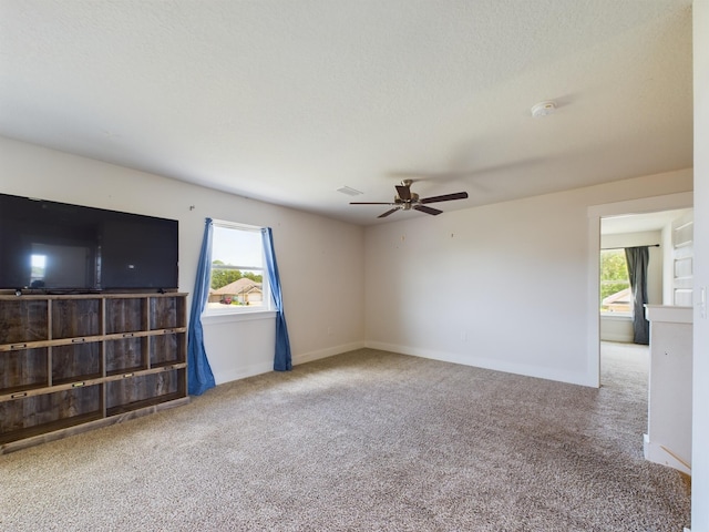 spare room featuring ceiling fan, a healthy amount of sunlight, and carpet