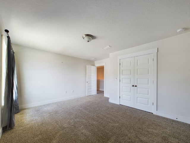 unfurnished bedroom with carpet, a textured ceiling, and a closet