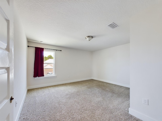 empty room with carpet and a textured ceiling