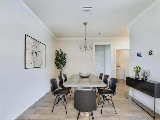 dining area featuring a notable chandelier, washer / dryer, and ornamental molding