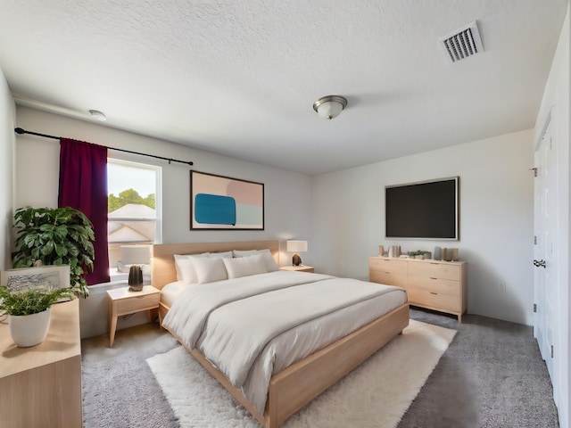 bedroom featuring carpet floors and a textured ceiling