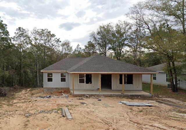 view of front facade featuring board and batten siding, a patio area, and roof with shingles