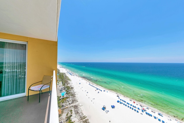 balcony featuring a beach view and a water view