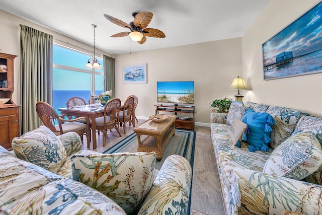 living room featuring ceiling fan with notable chandelier