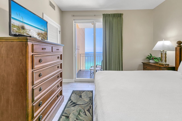 bedroom with access to outside, a water view, and light tile patterned floors