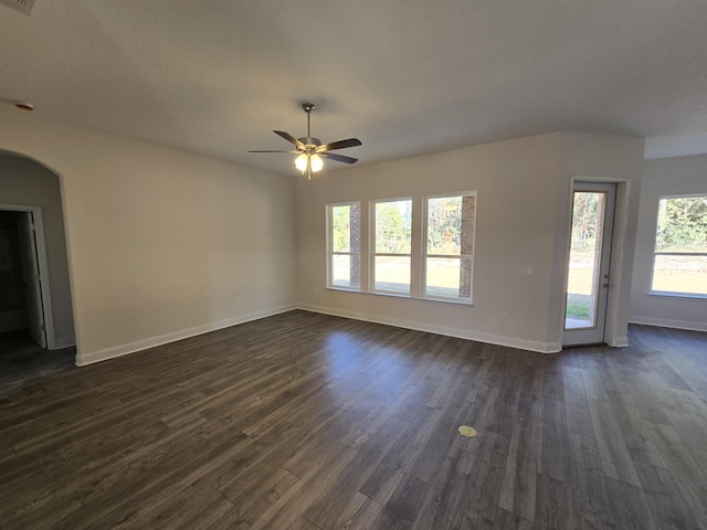 unfurnished living room with ceiling fan and dark hardwood / wood-style flooring